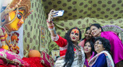 Laxmi Narayan Tripathi, high priestess of a convent of hijras, takes selfies with admirers at India’s 2019 Kumbh Mela religious festival.